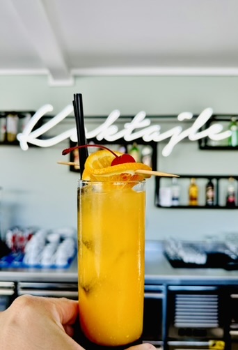 Oranger Cocktail im hohen Glas — Cocktails-Neon im Hintergrund