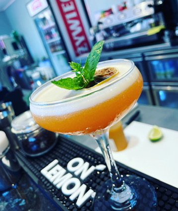 Whiskey Sour with a slice of passion fruit and a creamy foam