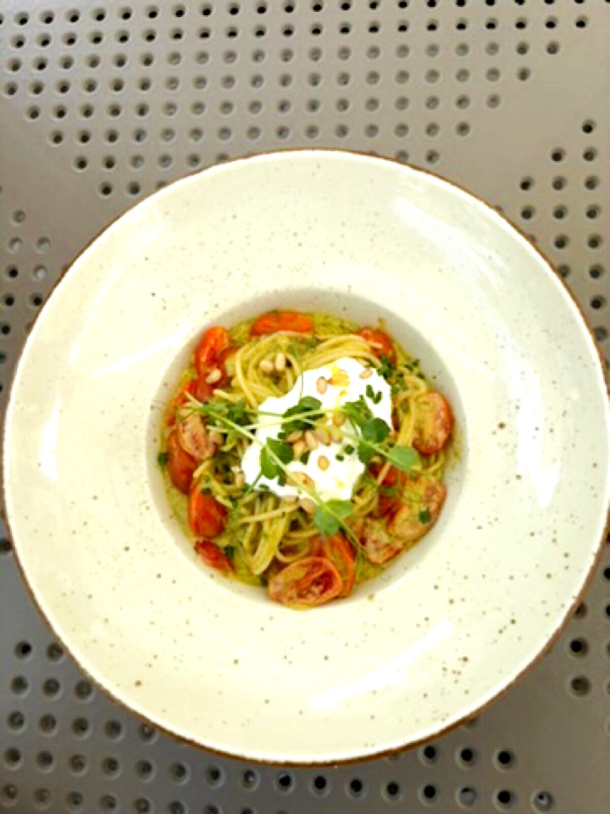 Spaghetti pesto with stracciatella di burrata, confit tomatoes and pine nuts